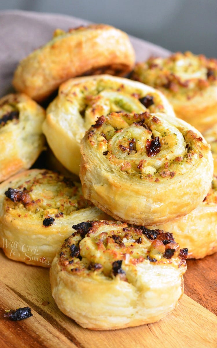 Pesto Chicken Pinwheels - Flaky pastry, juicy chicken, fresh pesto, sun dried tomatoes, and feta cheese rolled together to create a snack to delight your taste buds. 